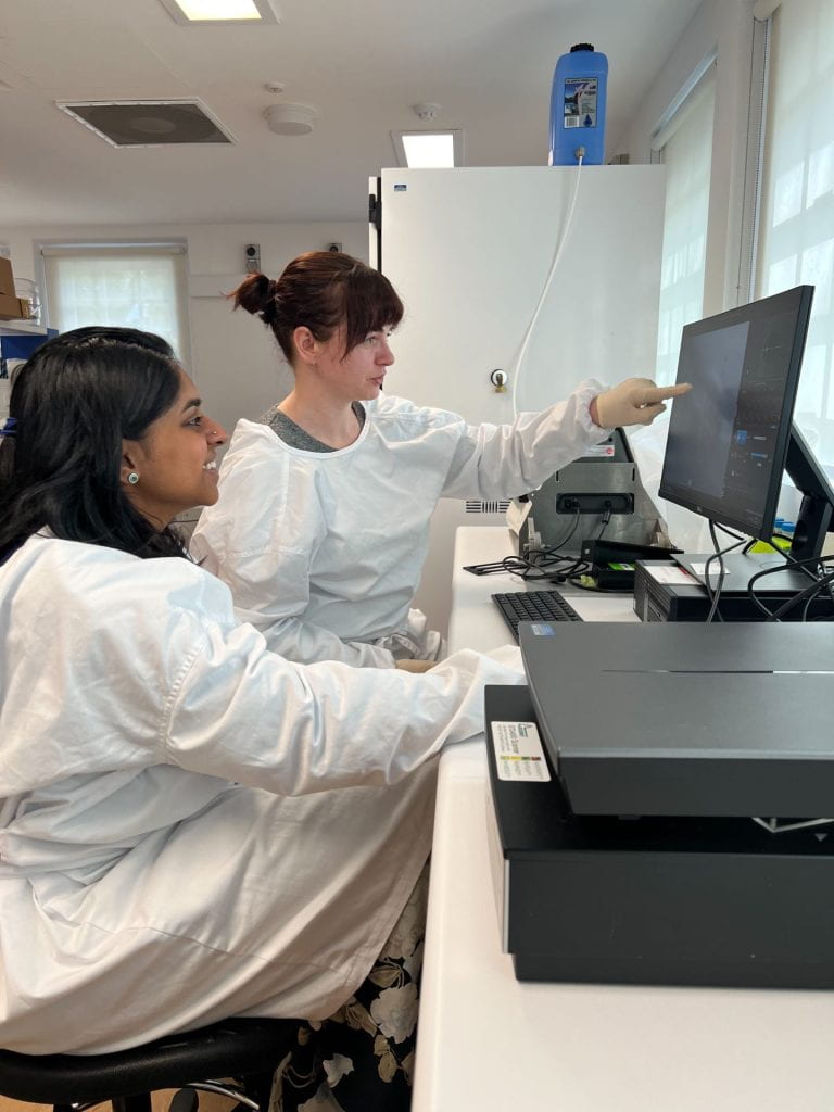 Vicky and Sneha in the lab looking at the image of a recent scan.